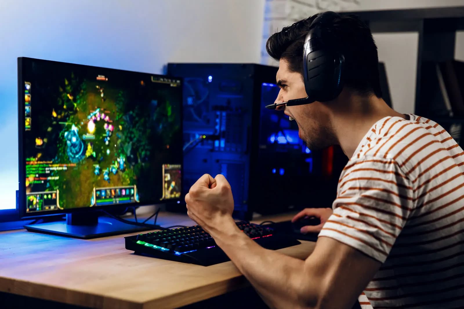 A creator at a desk with a camera at eye level and headphones on, lit from the front by a window.